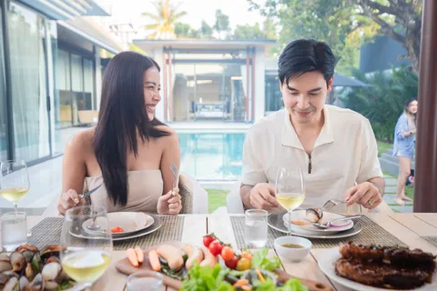 AVANA villa: a couple dining beside the pool